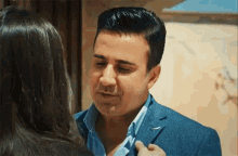 a man in a suit is talking to a woman in a black jacket