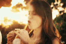 a woman is eating a sandwich with the name sophie on the bottom right