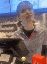 a woman behind a counter with a smiley face next to her face