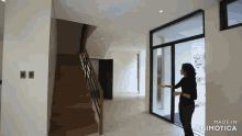 a woman is standing in a hallway with a staircase in the background and made in animatica written on the bottom