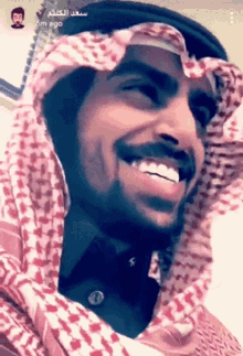 a close up of a man wearing a head scarf and a hat
