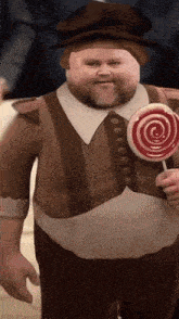 a man with a beard is holding a red lollipop