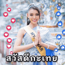 a woman wearing a sash that says myanmar holds her hands together