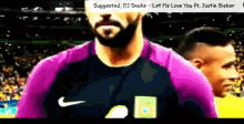 a man in a purple nike shirt is standing in a stadium