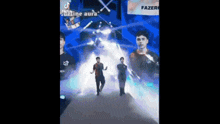 a group of young men are dancing on a stage in front of a projector screen .