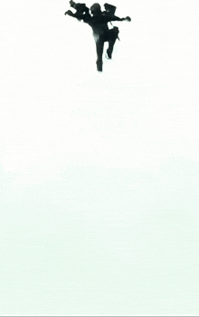 a silhouette of a person jumping in the air with their arms outstretched