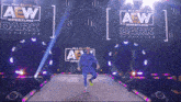 a wrestler is walking down the aisle in front of a sign that says all elite aew wrestling dark elevation