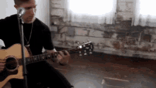 a man is singing into a microphone while playing a guitar