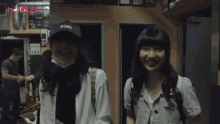 a woman wearing a black hat that says oklahoma smiles next to another woman