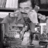 a black and white photo of a man and woman talking on a phone