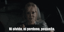 a woman is sitting in the driver 's seat of a car and saying `` ni olvido , ni perdono , pequeña ''