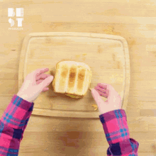 a person is making a sandwich on a cutting board .
