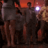 a man in a suit is dancing with a woman in a skirt at a party .