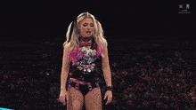 a female wrestler is standing in front of a bmac down sign