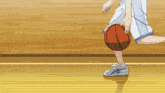 a person is dribbling a basketball on a hardwood court