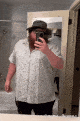 a man taking a selfie in front of a mirror with the hashtag minimax on the bottom right