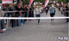 a group of people are running down a street and a gif is displayed at the bottom
