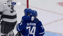 a hockey player named mcmann is hugging another player