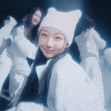 a woman wearing a white hat with cat ears is smiling