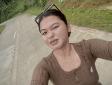 a woman wearing a polo shirt takes a selfie on a road