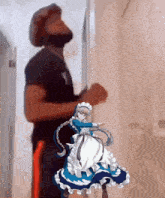 a man wearing a mask stands next to a maid doll
