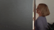 a woman is standing in front of a door with the words good written on it