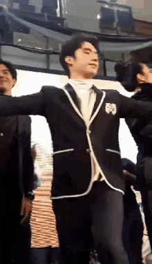 a man in a suit is dancing in front of a crowd