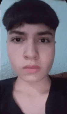 a close up of a person 's face with a black shirt on .