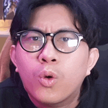 the man is wearing glasses and making a funny face .