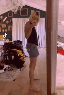 a woman is taking a picture of herself in front of a mirror .