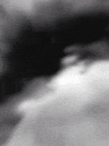 a black and white photo of a person 's face with a blurry background .