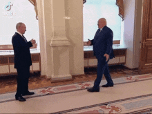 two men are shaking hands in a hallway with tiktok written on the bottom