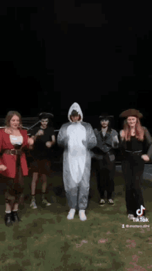 a group of people dressed as pirates and sharks are dancing in the dark .