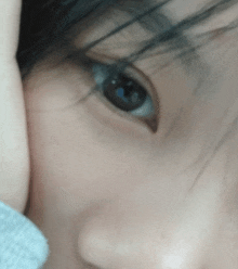 a close up of a person 's eye with their hand covering it