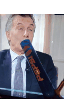 a man in a suit and tie is drinking from a pepsi can