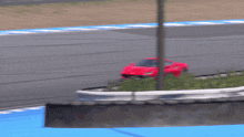 a red sports car is driving on a track