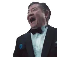 a man in a tuxedo and bow tie is laughing with his mouth wide open