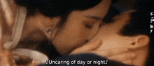 a woman is kissing a man on the cheek in a dark room .