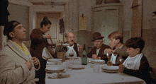 a group of people sit at a table with plates and glasses
