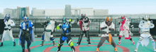 a group of people in costumes are dancing on a rooftop with a city in the background