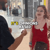 a woman in a red dress is talking to a man in a black shirt and the words it 's opinions based are above her