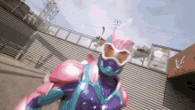 a person in a purple and pink superhero costume stands in front of a building