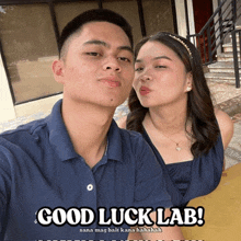 a man and a woman are posing for a picture with a caption that says good luck lab