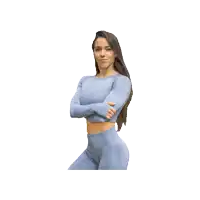 a woman with her arms crossed is wearing a blue crop top and leggings