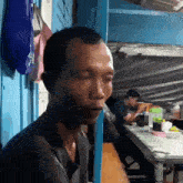 a man is sitting at a table with a blue wall