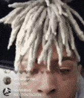 a close up of a person 's face with white dreadlocks on it .