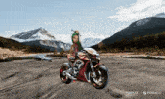 a girl with green hair is riding a red motorcycle in front of mountains
