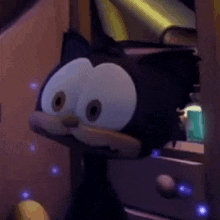 a stuffed cat with big eyes is sitting on a dresser .