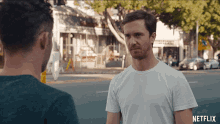 two men standing on a street with netflix written on the bottom right