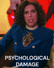 a woman wearing a blue sweater with a heart on it and the words psychological damage